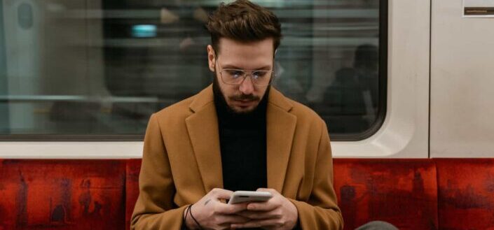 Man Using a Smartphone in a Train