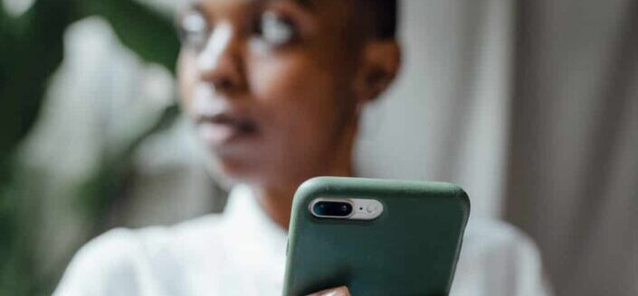 Black woman using smartphone while looking away