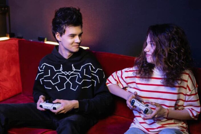 Couple Playing Games on a Red Couch