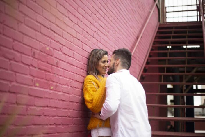 Man and woman Standing Beside Red Brick Wall About to Kiss