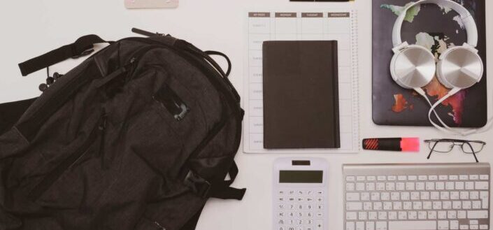 Backpack and Notebook Laid Out Near a Calculator