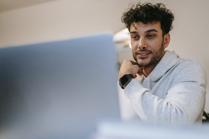 man smilling in front of his laptop