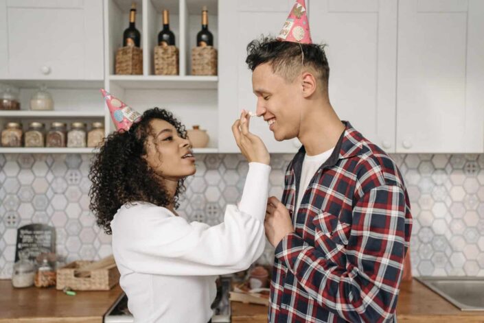 A couple wearing party hat in kitchen
