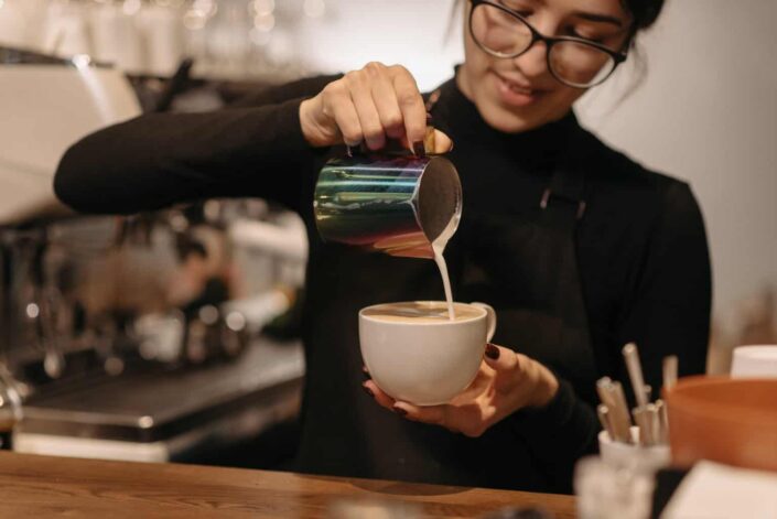 A female barista making coffee