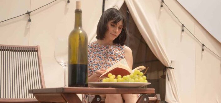 a woman reading a book while glamping