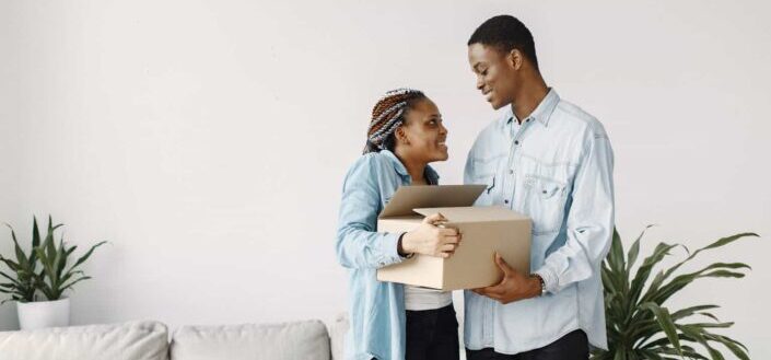 Young Couple Holding a Cardboard Box Together