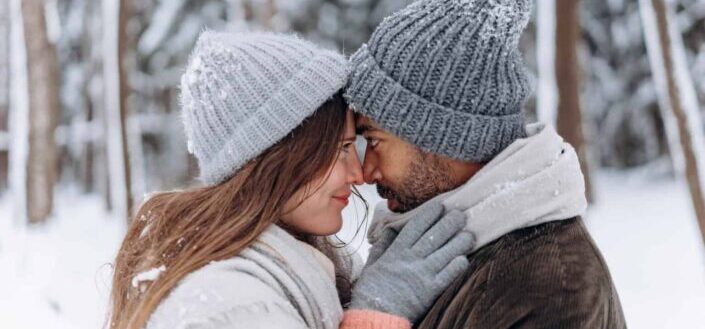 couple kissing in snowy forest