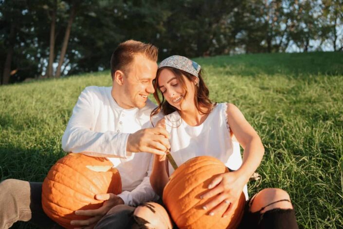 Couple carving pumpkins in fall