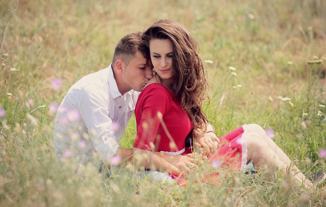 couple sitting on the grass field