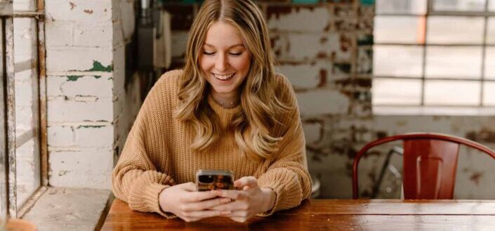 woman smilling while texting