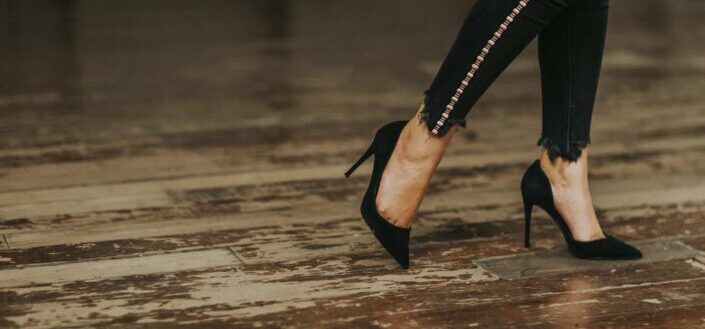 Woman wearing black suede stilettos