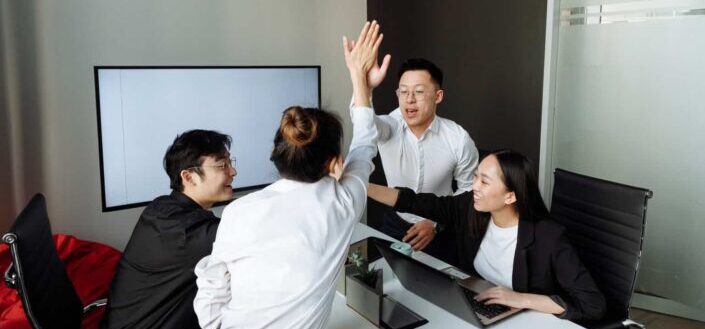 colleagues having high five at meeting
