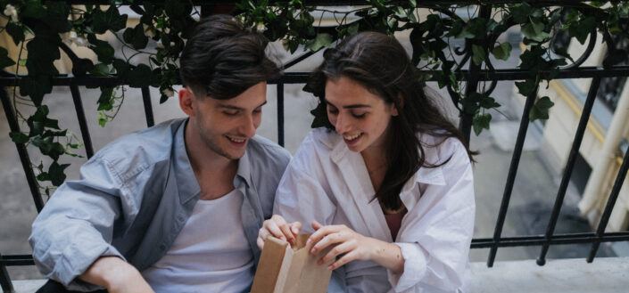 couple holding brown paper bag