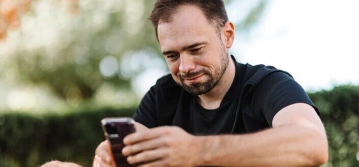 Man in black shirt using a cellphone