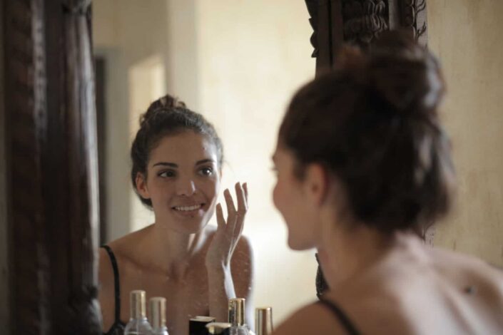 Woman checking on her face in the mirror