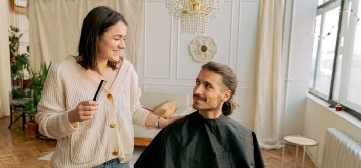 Woman cutting mans hair