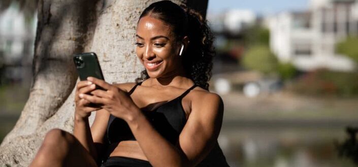 Woman in black sports bra holding phone