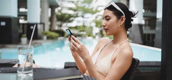 woman texting while chilling in outdoor pool
