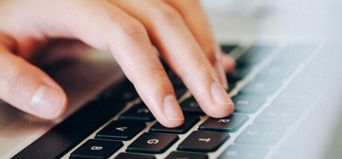 person typing on laptop keyboard